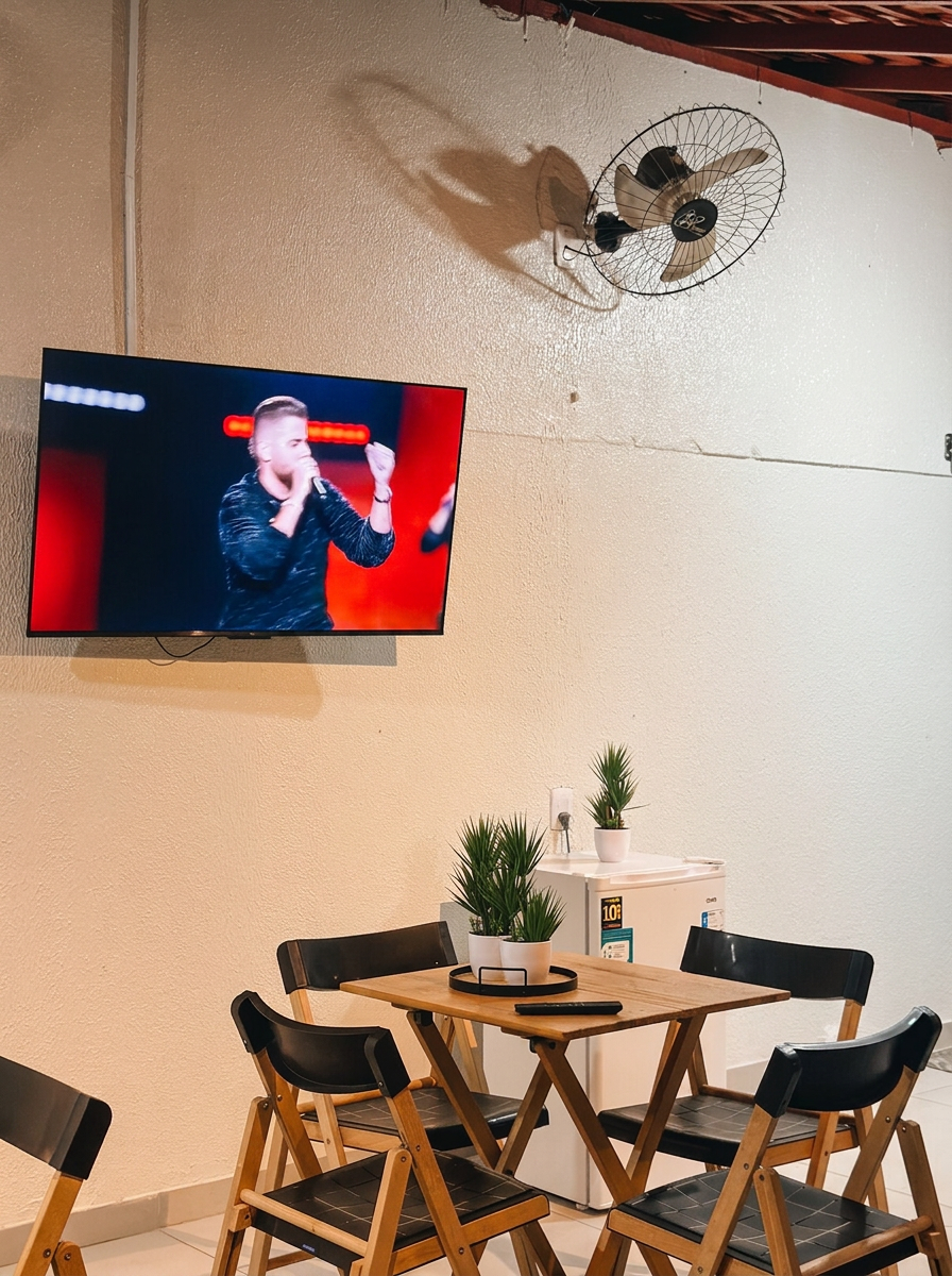 Área de estar com TV e mesa de jantar da Suíte do Boto